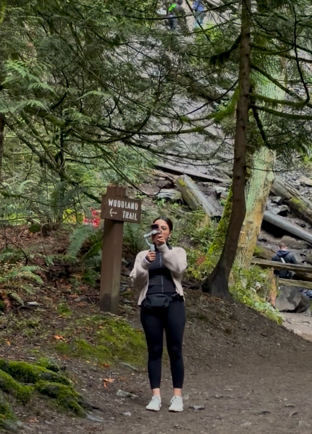 Negin filming with a phone gimbal on a woodland trail